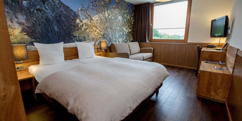 Hotelkamer met houten vloer en houten details in een skihotel. 